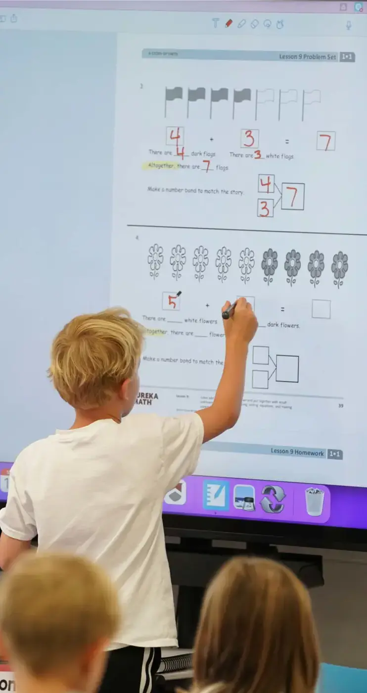 Porter-Gaud student solves math questions on the interactive whiteboard in class